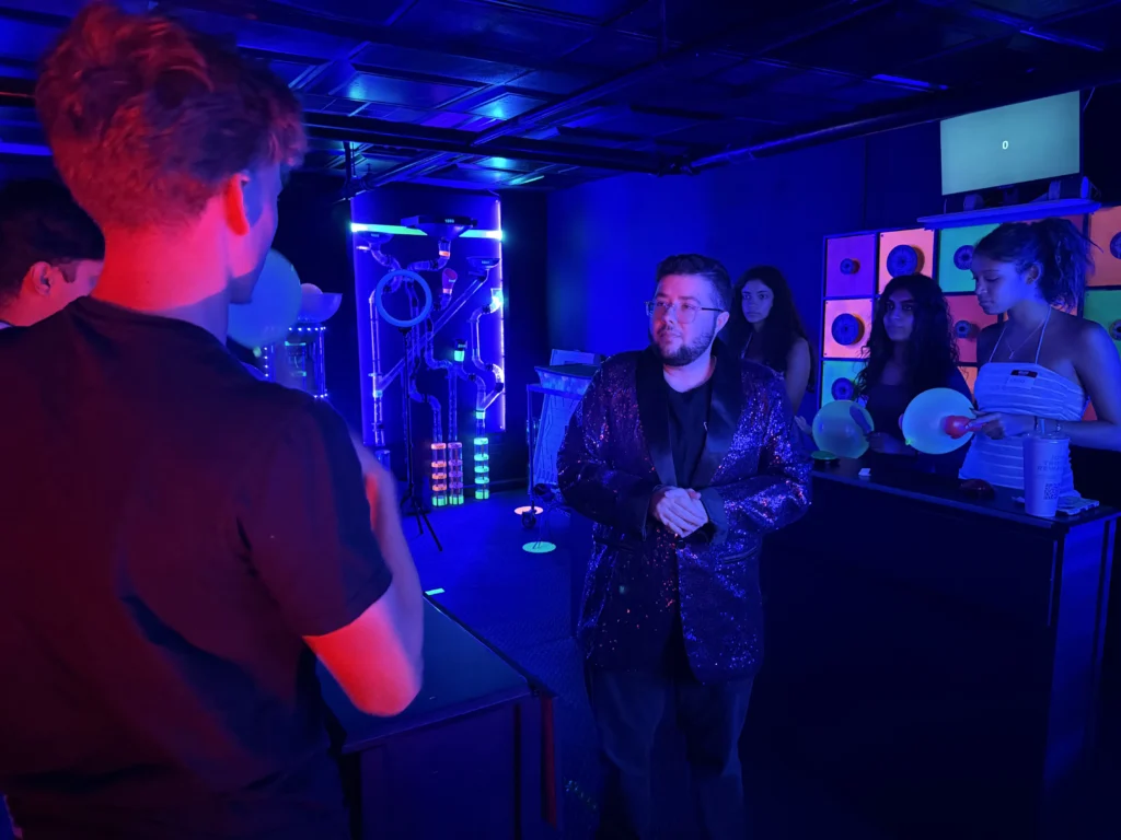 Host and players in the neon-lit game show studio
