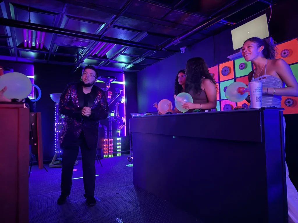 Host leading a game while players compete at the podiums