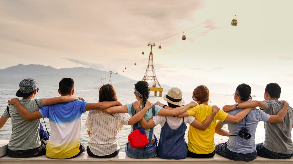 Group of friends sitting arm in arm looking at the view