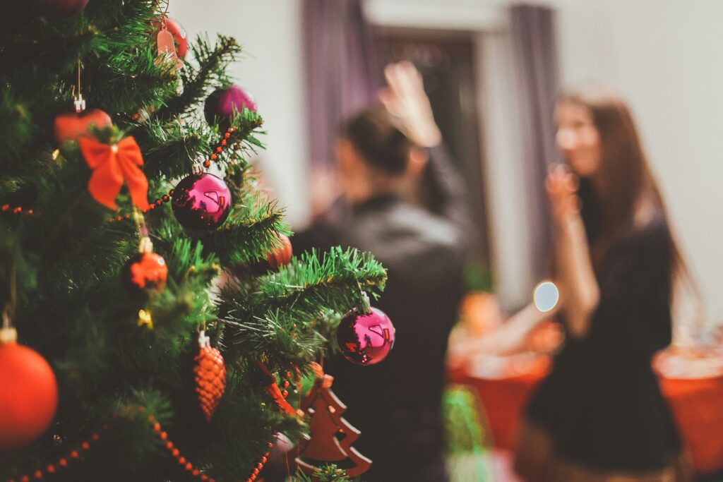 Holiday party next to a decorated Christmas tree