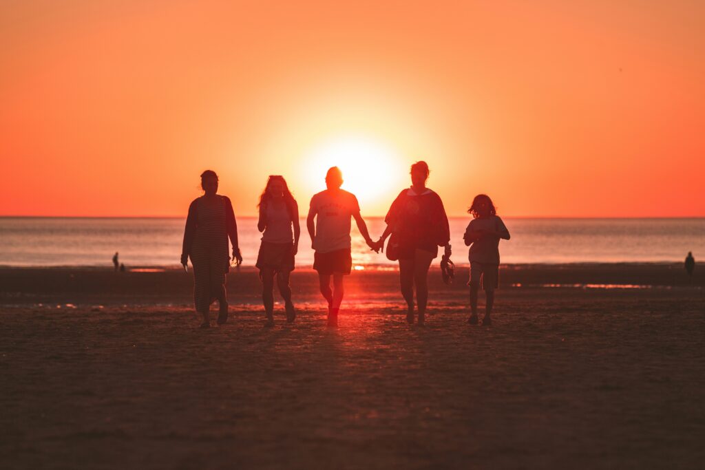 Family walking on the beach at sunset